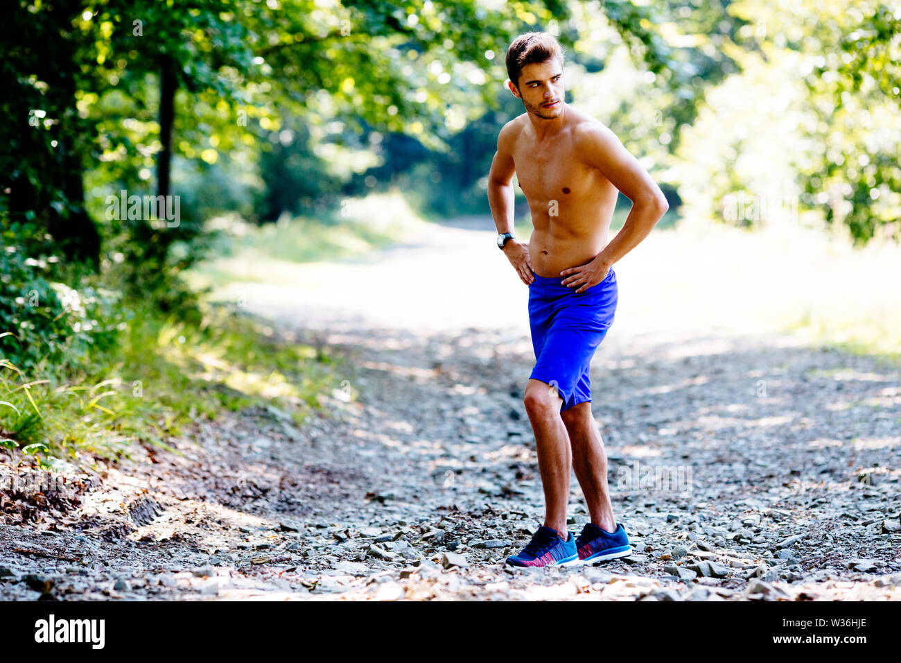 Muskulösen jungen Mann weg schauen, während Sie Pause vom Joggen in den Bergen Stockfoto