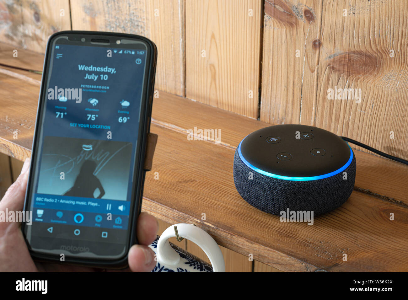 Amazon Alexa App auf einem Mobiltelefon Ausgang ansteuern von einem Echo dot Lautsprecher. Stockfoto