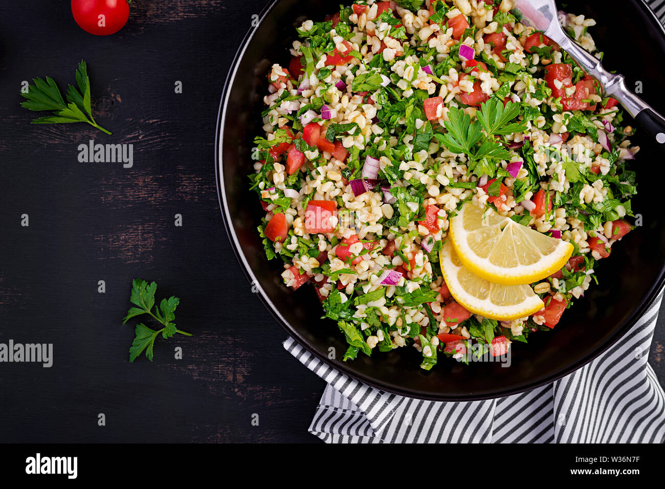Tabbouleh Salat. Traditionelle orientalische oder arabische Gericht. Levantinischen vegetarischen Salat mit Petersilie, Minze, Bulgur, Tomate. Ansicht von oben Stockfoto