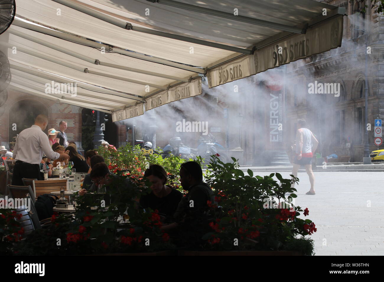 Sommer Street Café Diners in Budapest durch Düsen kalte Luft gekühlt wird Stockfoto
