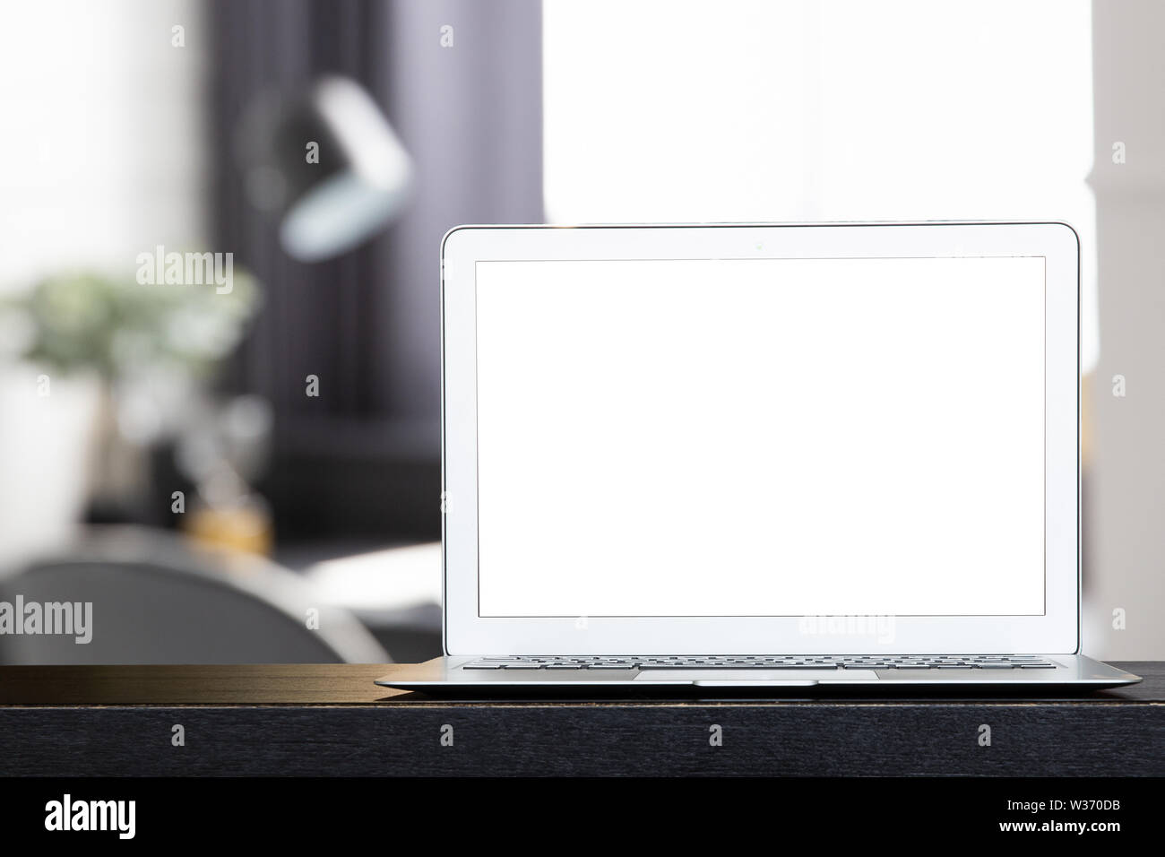 Mock up von leeren modernen Laptop auf dem schwarzen Schreibtisch. Persönlichen laptop computer auf dunklem Holz Tisch in modernes weißes Wohnzimmer. Stockfoto