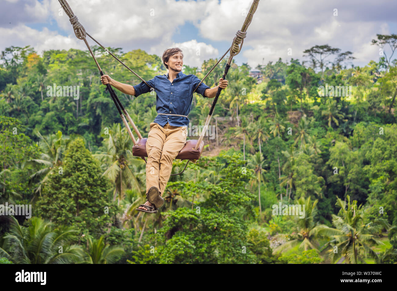 Junger Mann im Dschungel Regenwald der Insel Bali, Indonesien schwingen.  Swing in den Tropen. Schaukeln - Tendenz von Bali Stockfotografie - Alamy