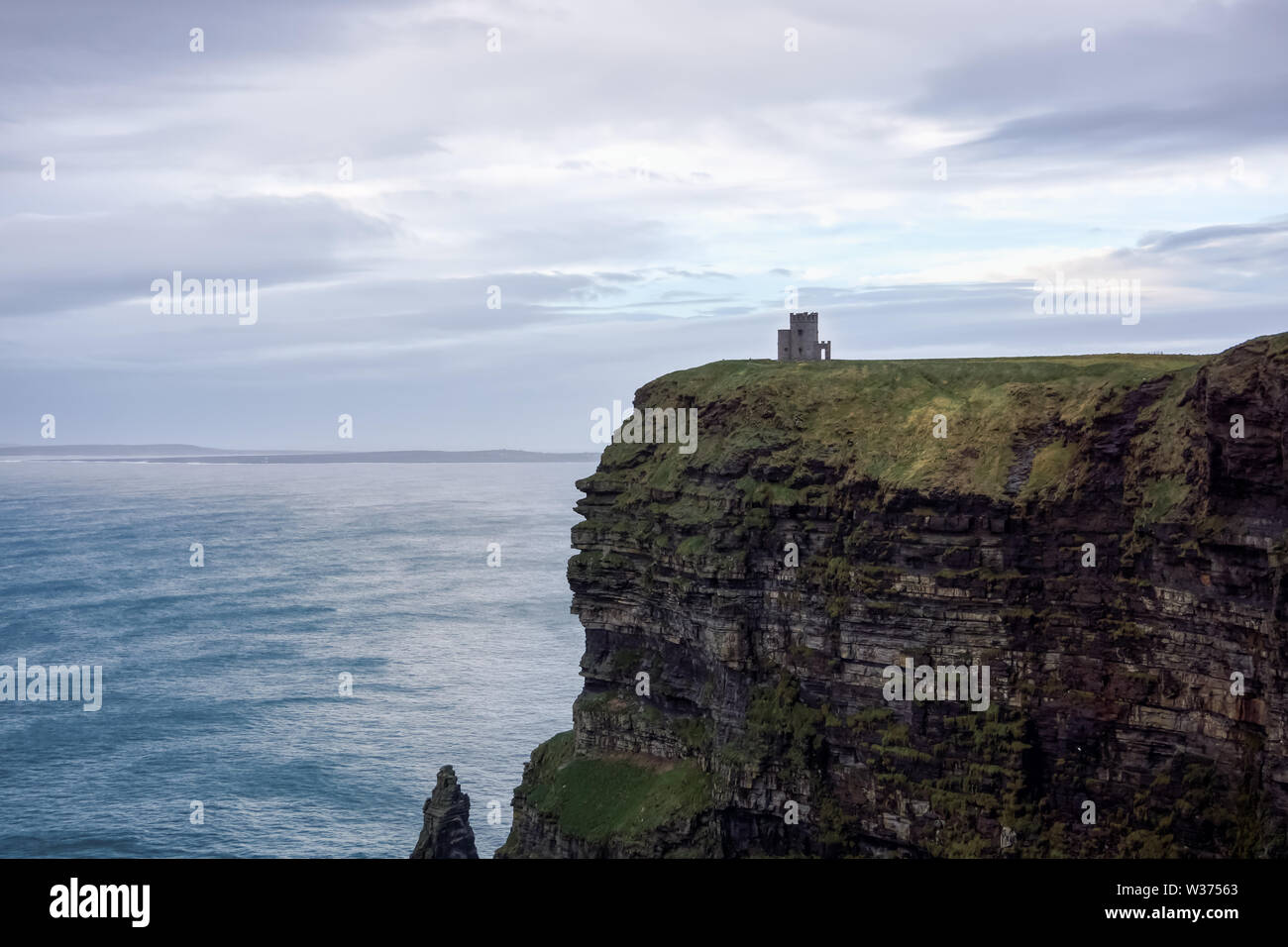 Die Klippen von Moher, die in den wilden Atlantik mit Ruinen des Turms am Rande der Klippe Stockfoto