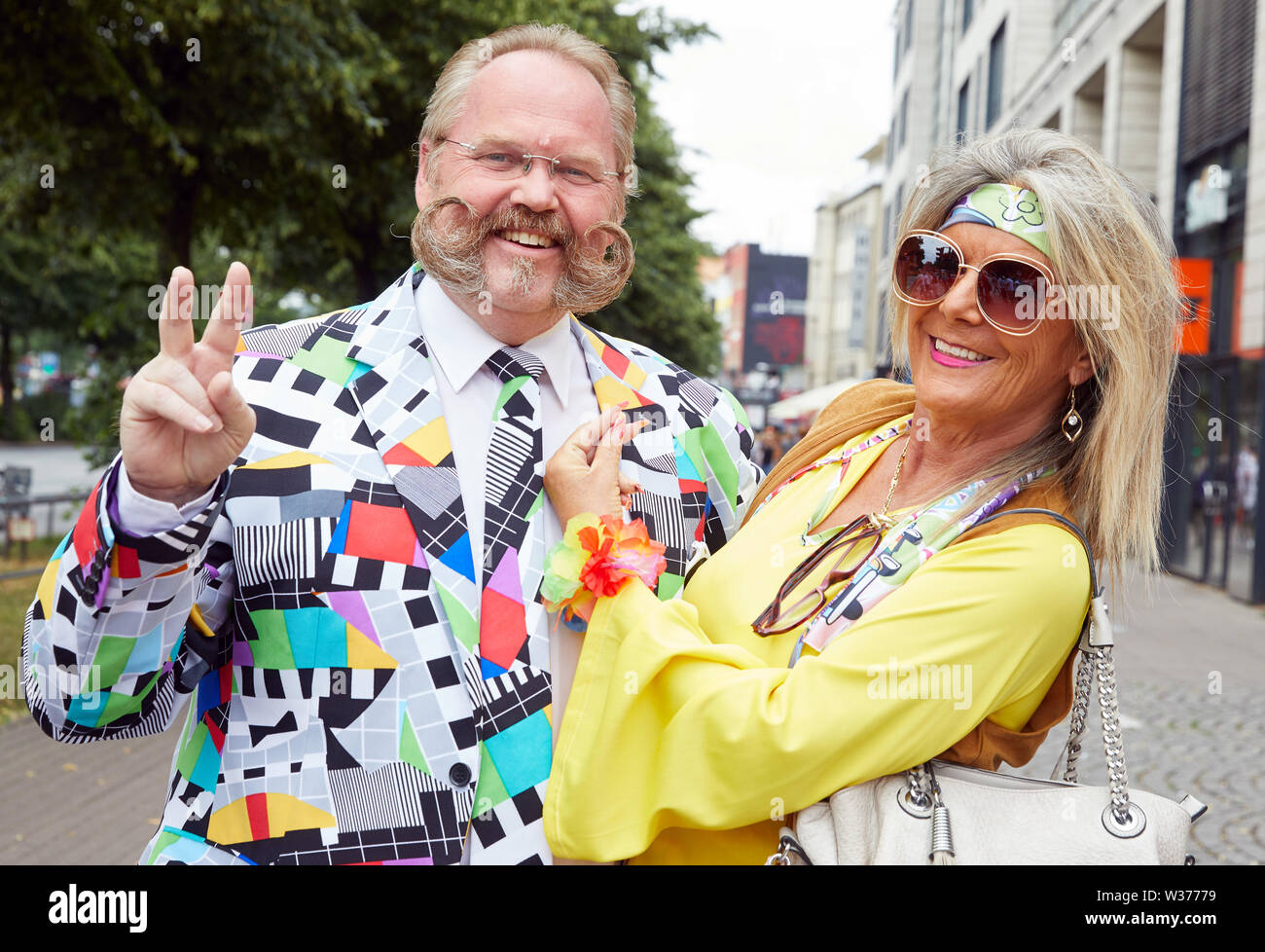Hamburg, Deutschland. 13. Juli, 2019. Thomas Klingenberg und seine Frau Gundula aus Stuttgart, die Besucher des Schlagermoves, posieren in bunten Kostümen auf der Reeperbahn. Quelle: Georg Wendt/dpa/Alamy leben Nachrichten Stockfoto