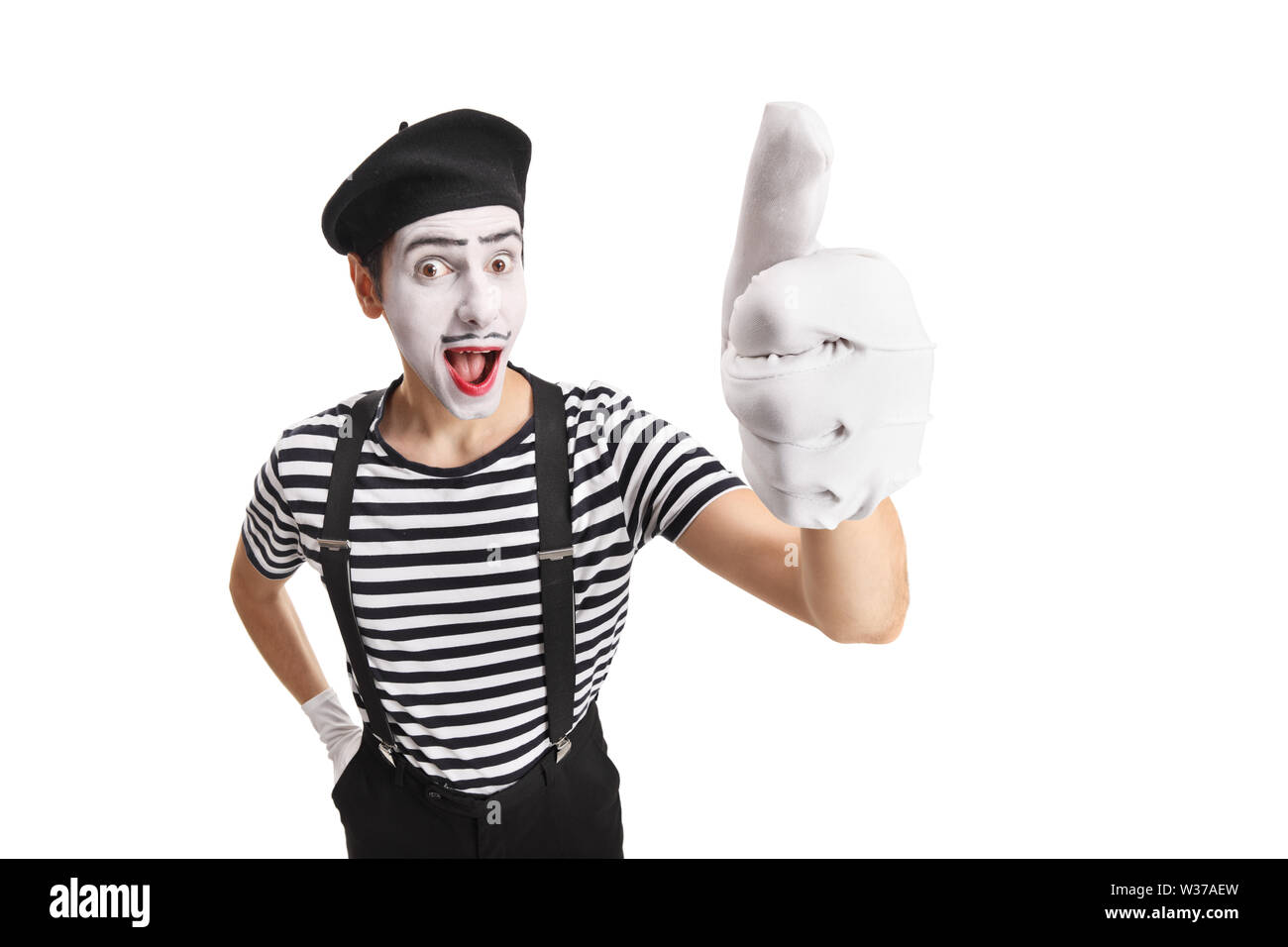 Fröhlicher junger Pantomime Mann zeigt auf weißem Hintergrund Daumen hoch isolierten Stockfoto