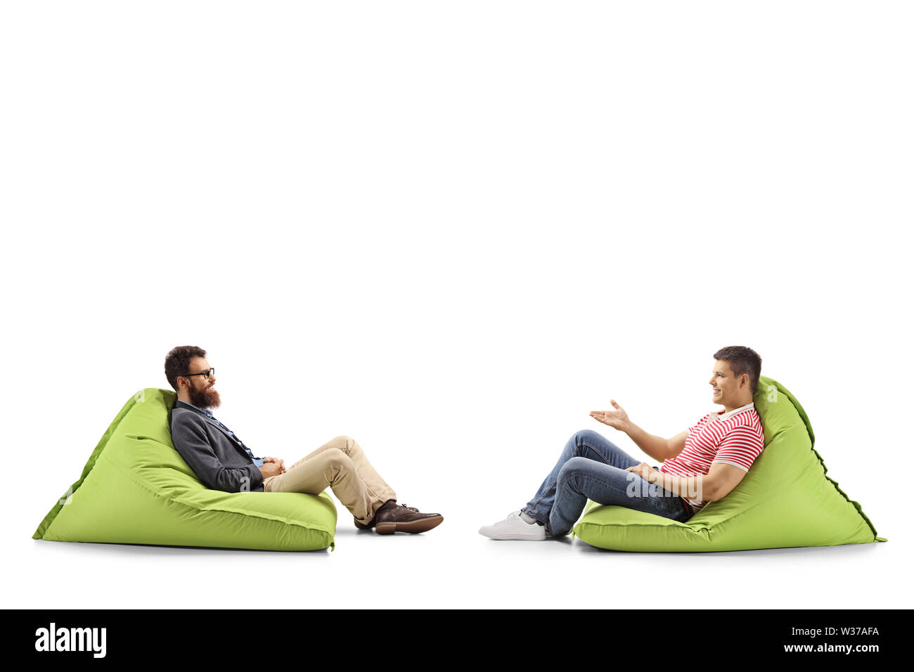 Volle Länge Profil Schuß von zwei Männer auf sitzsäcken ein Gespräch auf weißem Hintergrund Stockfoto