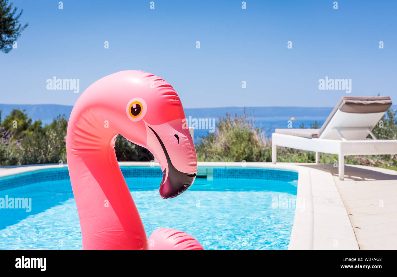 Rosa flamingo Wasserbett im Schwimmbad mit Mittelmeer im Hintergrund Stockfoto