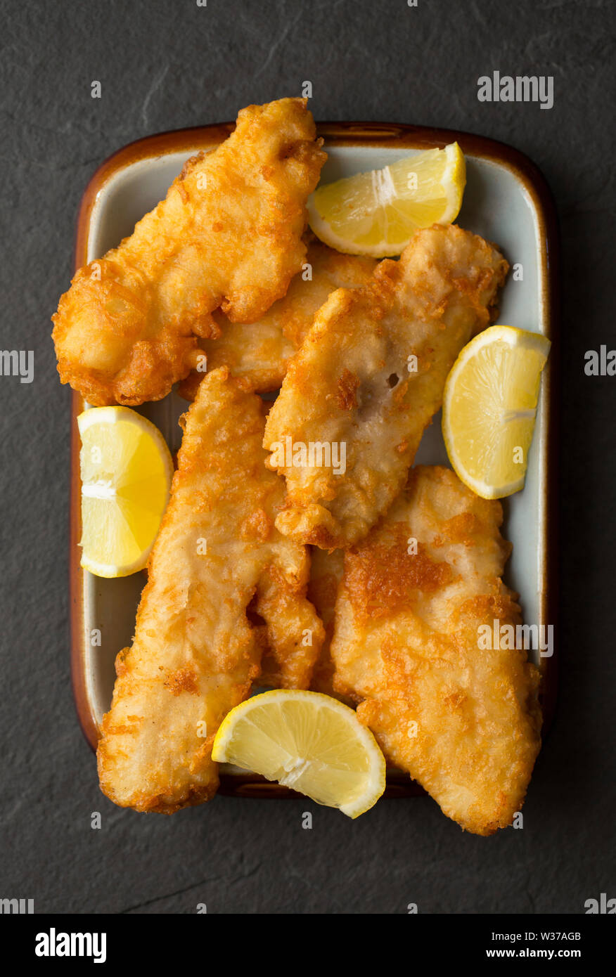 Filets von Frittierten schmollen, Trisopterus luscus, die im Teig beschichtet wurden und tief zu Hause gebratenen Fisch und Chips Abendessen zu machen. Die SCHMOLLEND Stockfoto