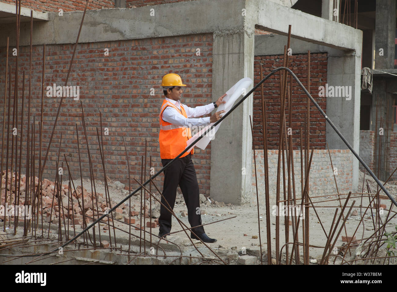 Architekt mit Bauplan auf der Baustelle Stockfoto