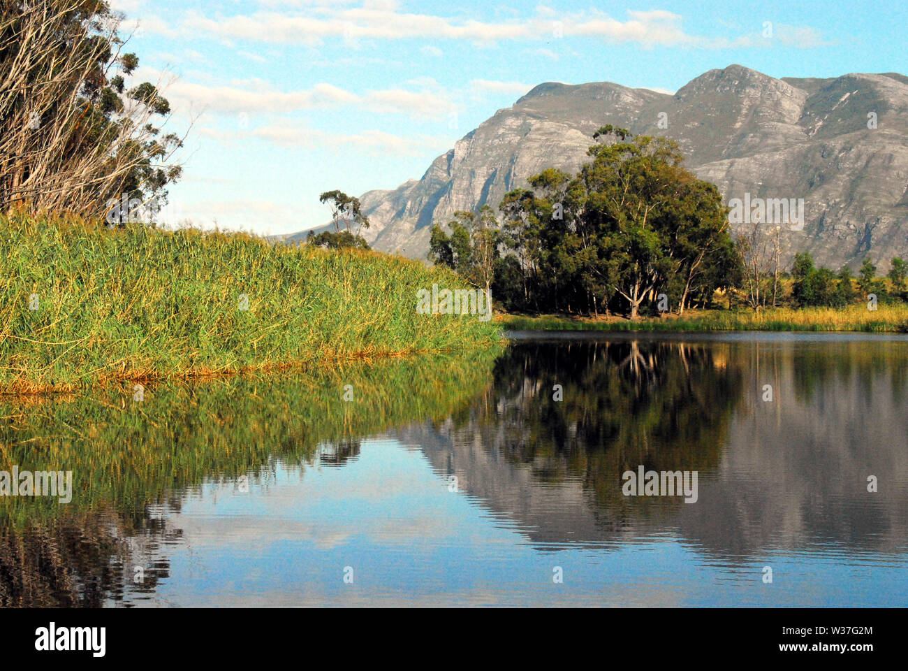 Eine schöne Berglandschaft Reflexion von einem Boot auf einem Fluss in Südafrika. Stockfoto