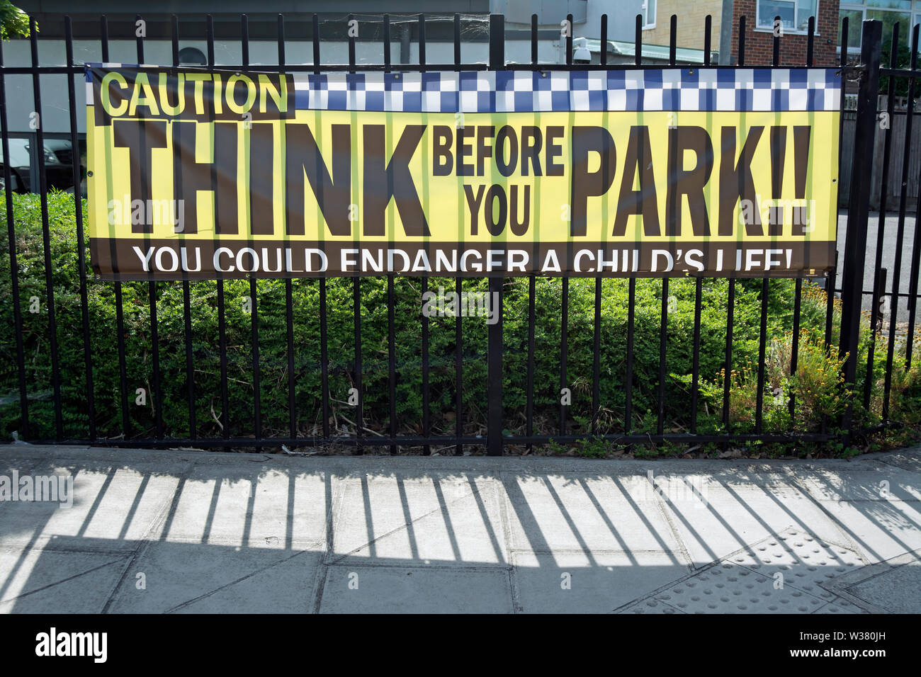 Denken Sie, bevor Sie den Park, melden Sie sich an Autofahrer außerhalb einer Schule in Twickenham, Middlesex, England Stockfoto