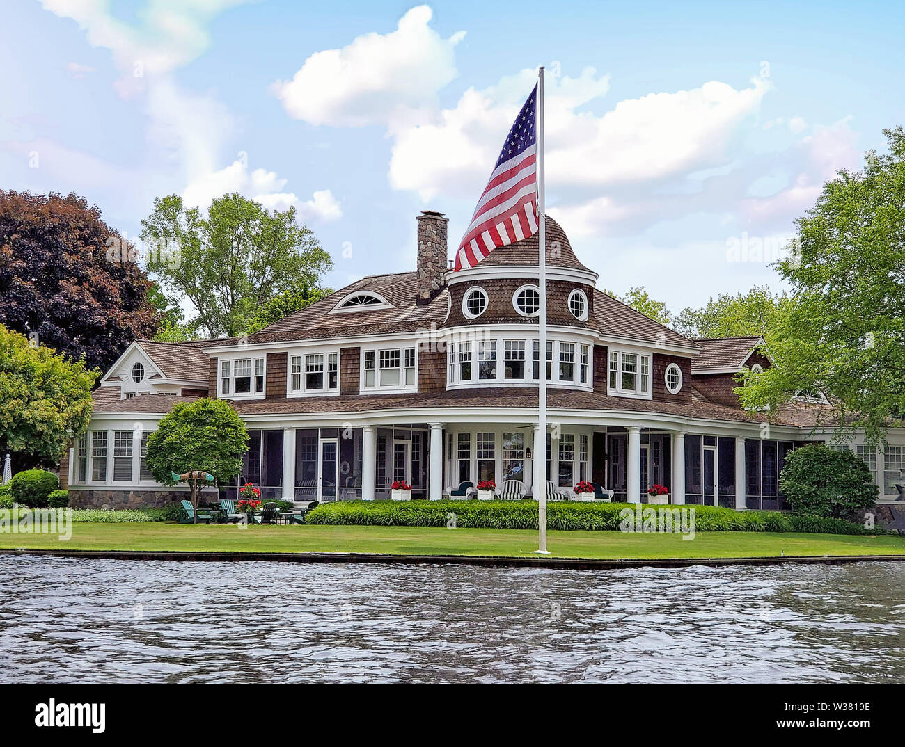 Luxus riverfront Sommer home mit amerikanischer Flagge Stockfoto