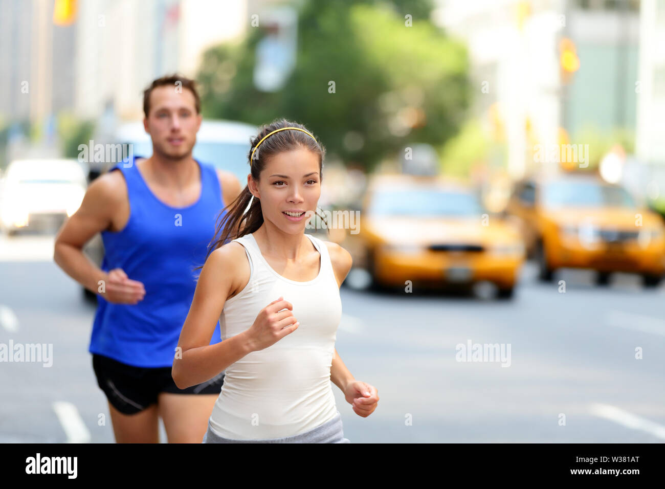 Stadt Läufer - Urban new yorker Menschen in belebten Straße in New York NYC läuft. Junge Erwachsene asiatische kaukasischen Joggen im Verkehr auf Manhattan im Sommer. Stockfoto