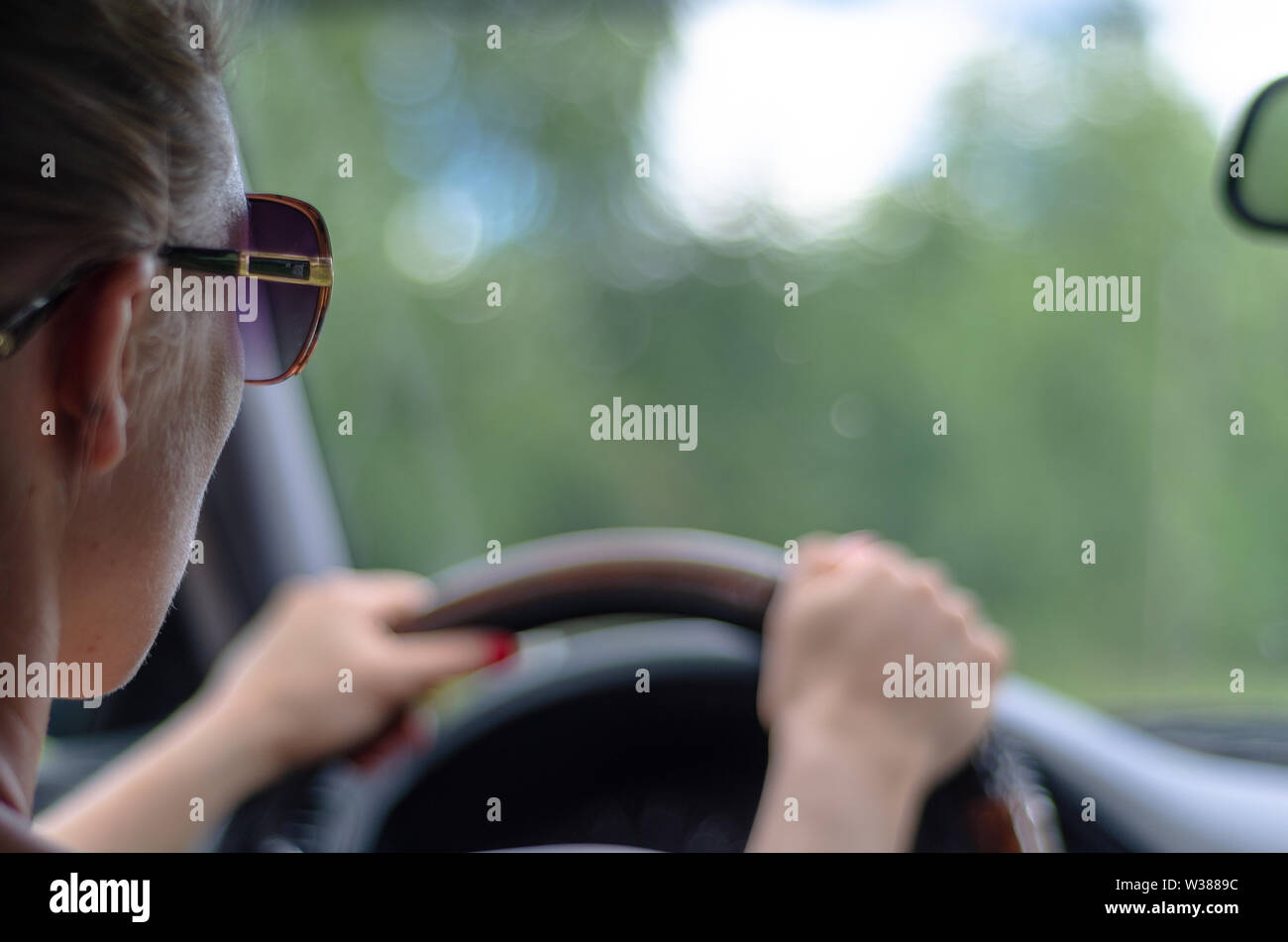 Frau Fahrer in einem Auto gegen einen unscharfen Frontscheibe Stockfoto