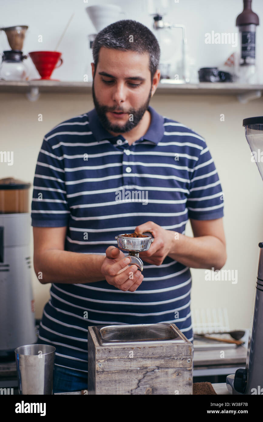 Männliche barista über eine Kaffeemaschine eine schöne Tasse Kaffee zu machen. Cafe Arbeiter Vorbereitung einen Kaffee Stockfoto