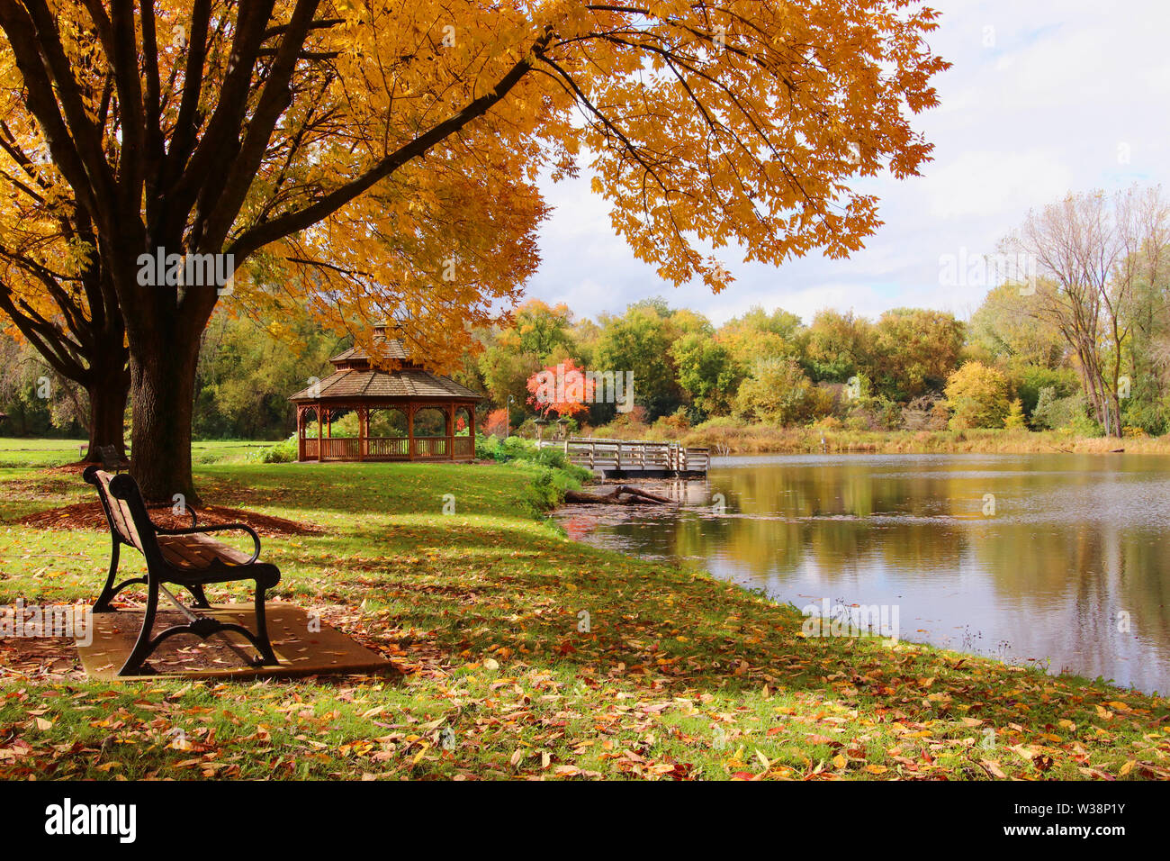 Schönen Herbst Landschaft mit bunten Bäumen rund um den Teich und einem Pavillon aus Holz in einem Stadtpark. Lakeview Park, Middleton, Madison, WI, USA. Stockfoto