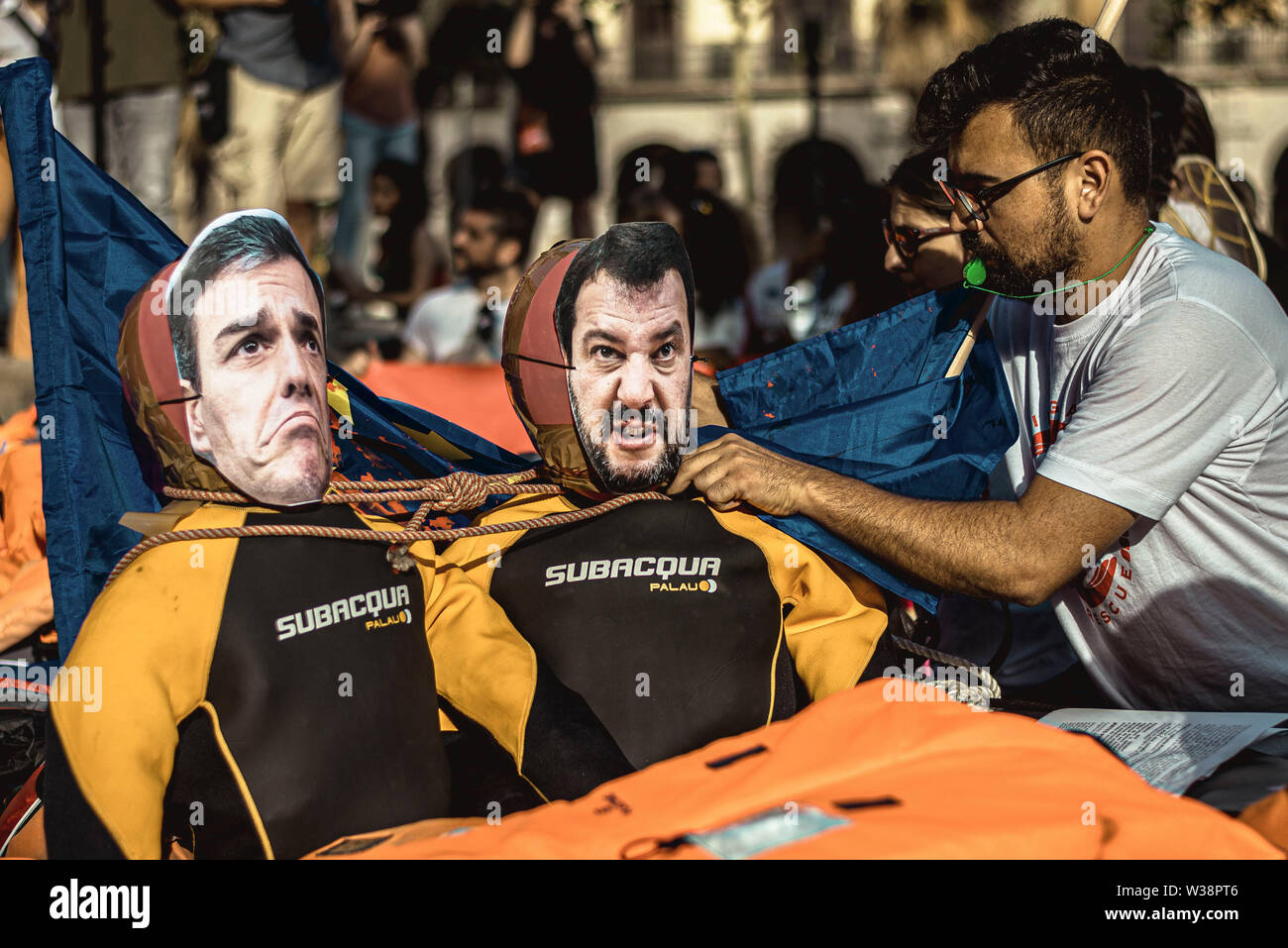 Barcelona, Spanien. 13. Juli, 2019. Ein menschenrechtsaktivist mit bereitet Marionetten Darstellung des Spanischen Pedro Sanchez und der Italiener Matteo Salvini während eines Protestes über das Mittelmeer migration Krise Credit: Matthias Oesterle/Alamy leben Nachrichten Stockfoto