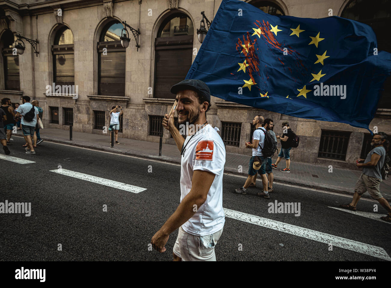 Barcelona, Spanien. 13. Juli, 2019. Ein menschenrechtsaktivist mit einem blutigen EU-Flagge Proteste über die Lage der Migranten, das Mittelmeer Credit: Matthias Oesterle/Alamy leben Nachrichten Stockfoto