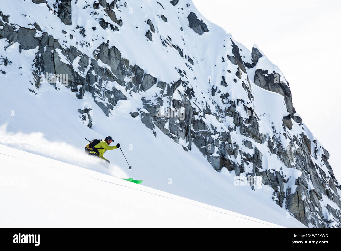 Skifahrer im Hinterland von Alaska Talkeetna Berge. Er Datenvernichtung frischen Powder unter Felsen aus Granit mit frischem Schnee bedeckt. Stockfoto