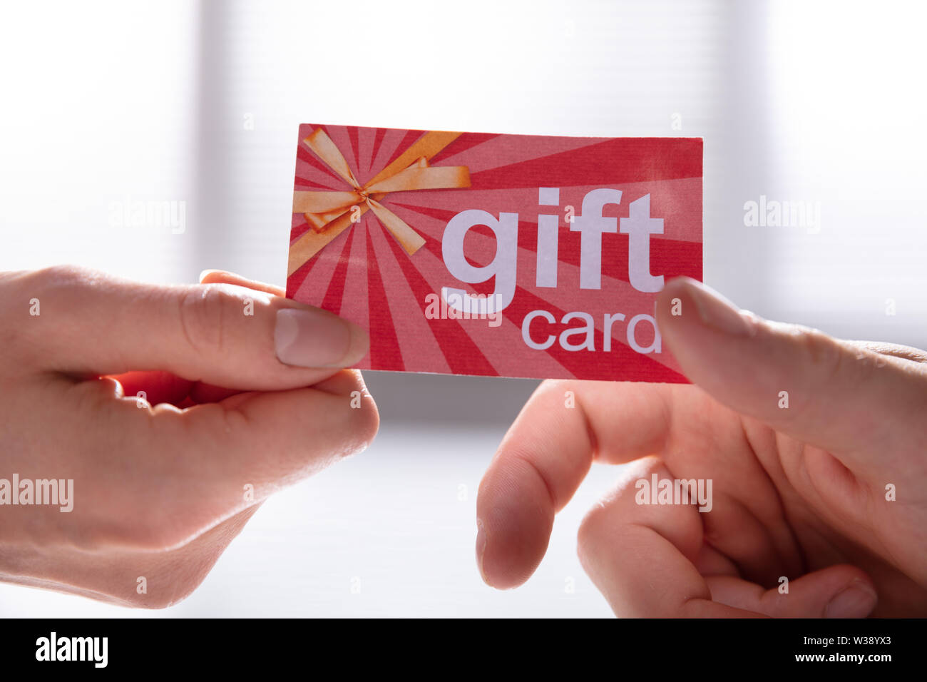 In der Nähe der weiblichen Hand geben Geschenkgutschein zu ihrem männlichen Partner Stockfoto