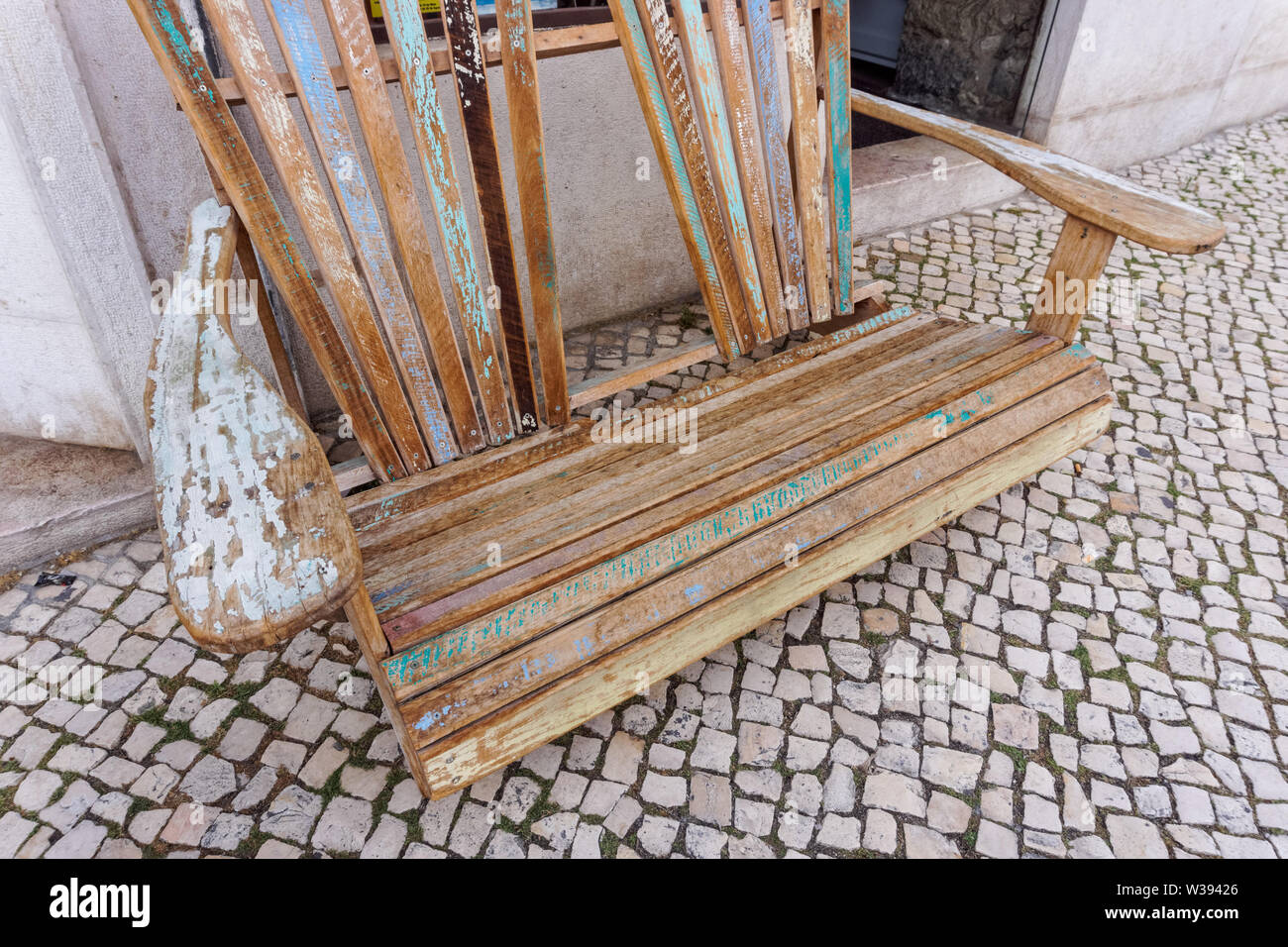Alte Holzbank auf gepflasterten Gehweg in Lissabon, Portugal Stockfoto