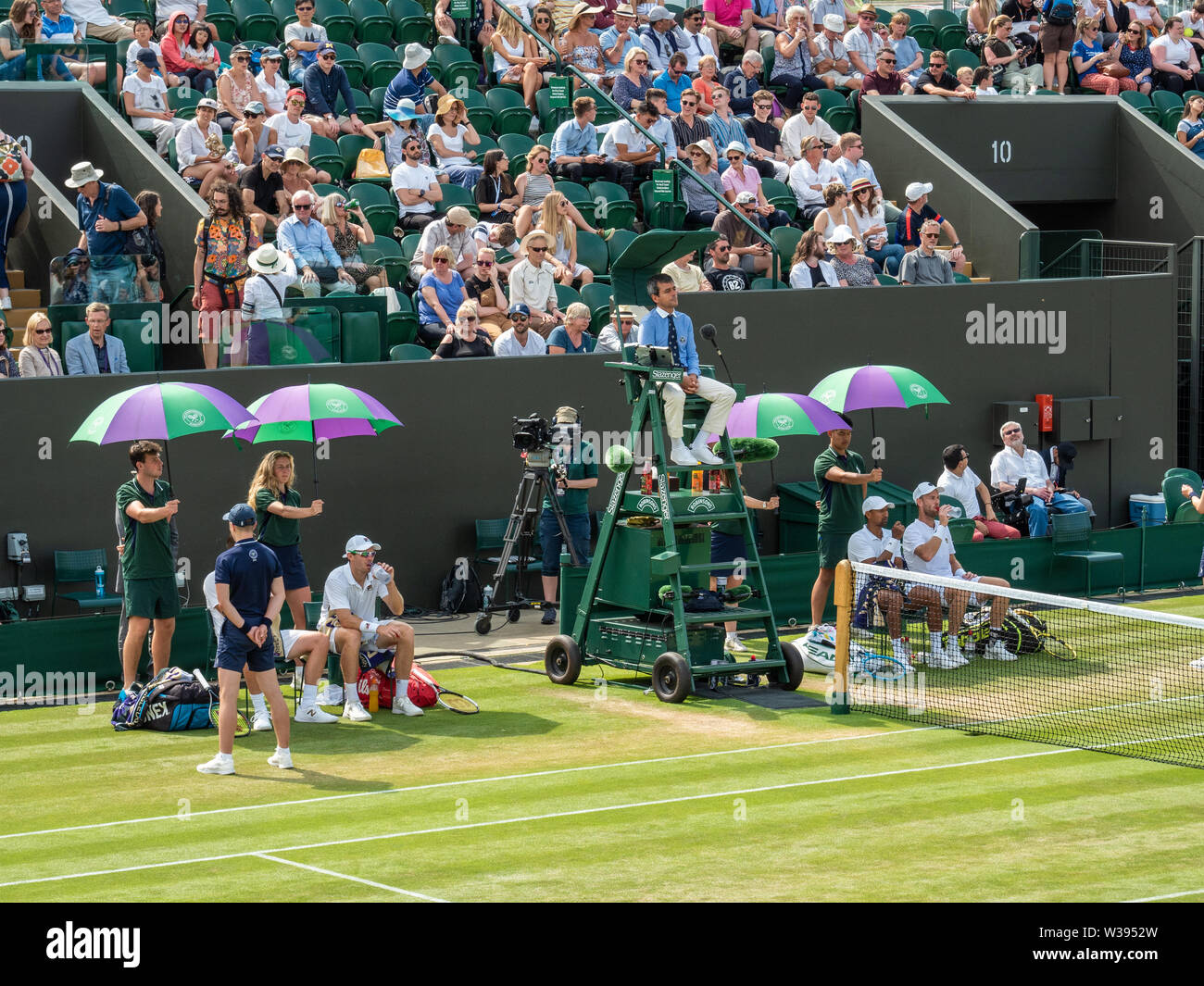 Herren verdoppelt Partner, die beim Wimbledon Tennis Tournament, London, England, eine Pause zwischen den Spielen einlegen Stockfoto
