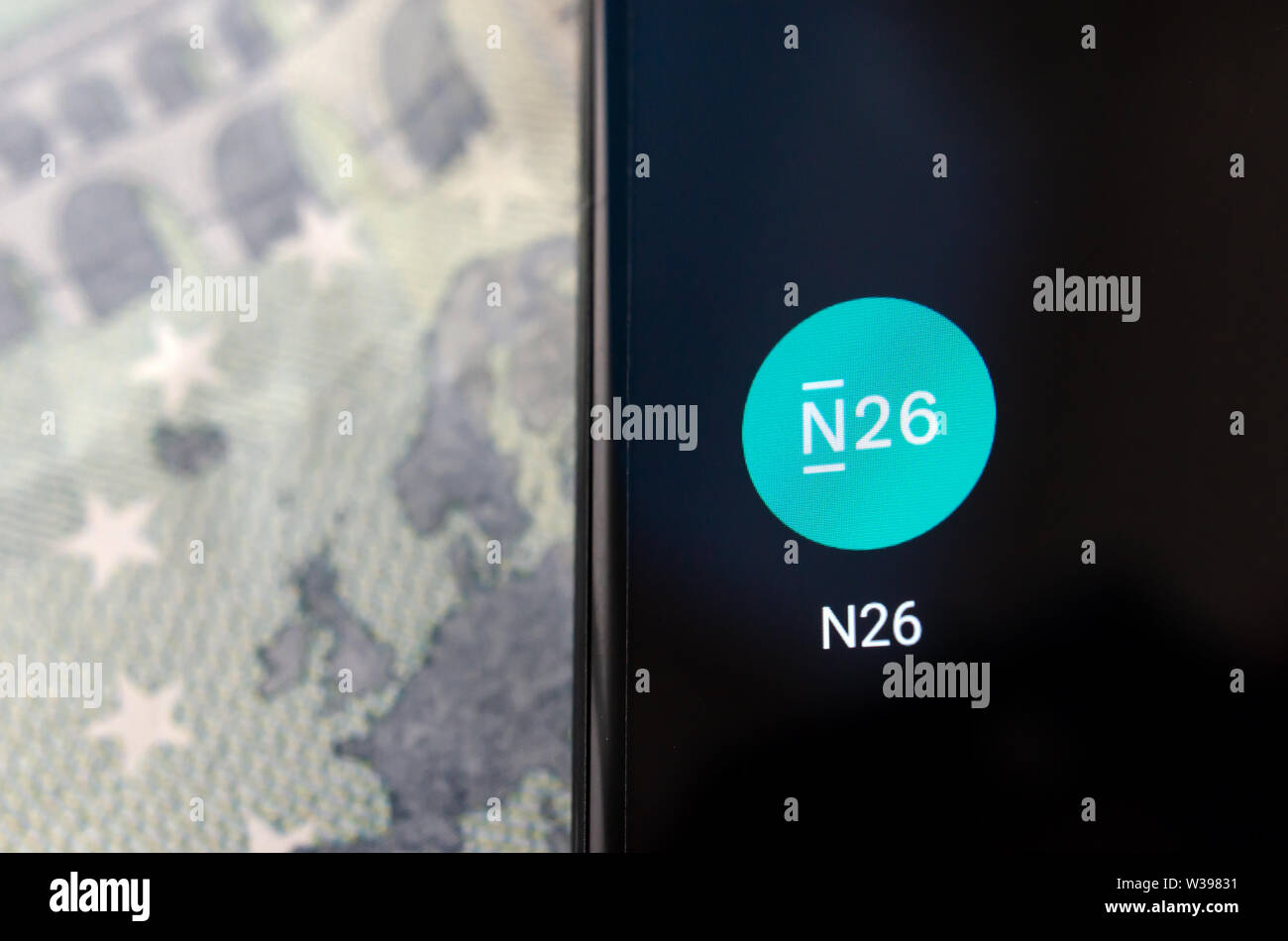 N26 Mobile Bank App auf dem Bildschirm des Smartphones in einem Schwerpunkt und Banknote im verschwommenen Hintergrund. Stockfoto