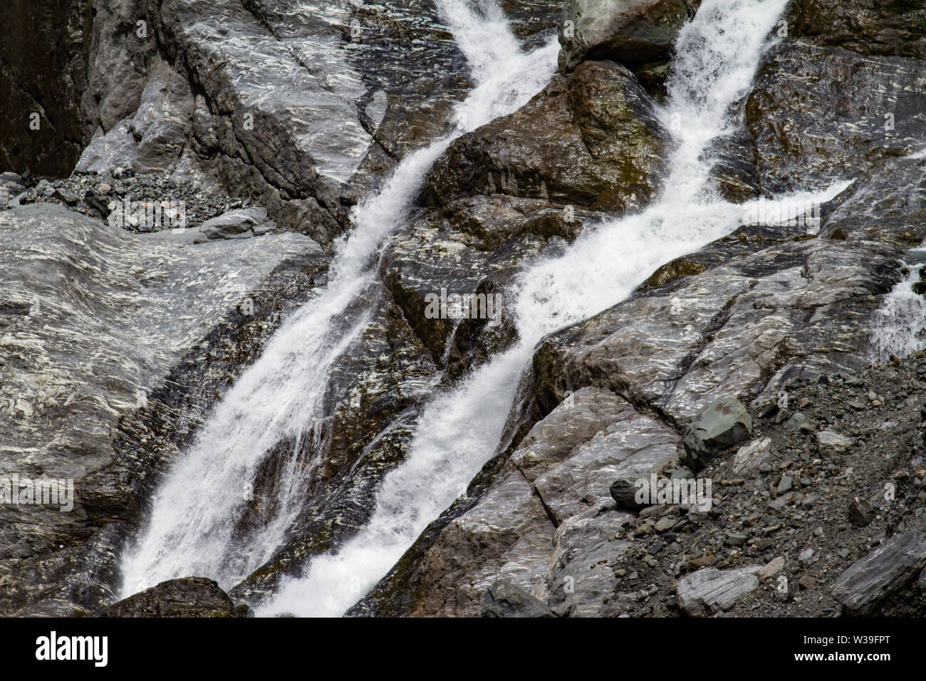 Kleine Wasserfälle an der Felswand durch Regen gebildet Stockfoto