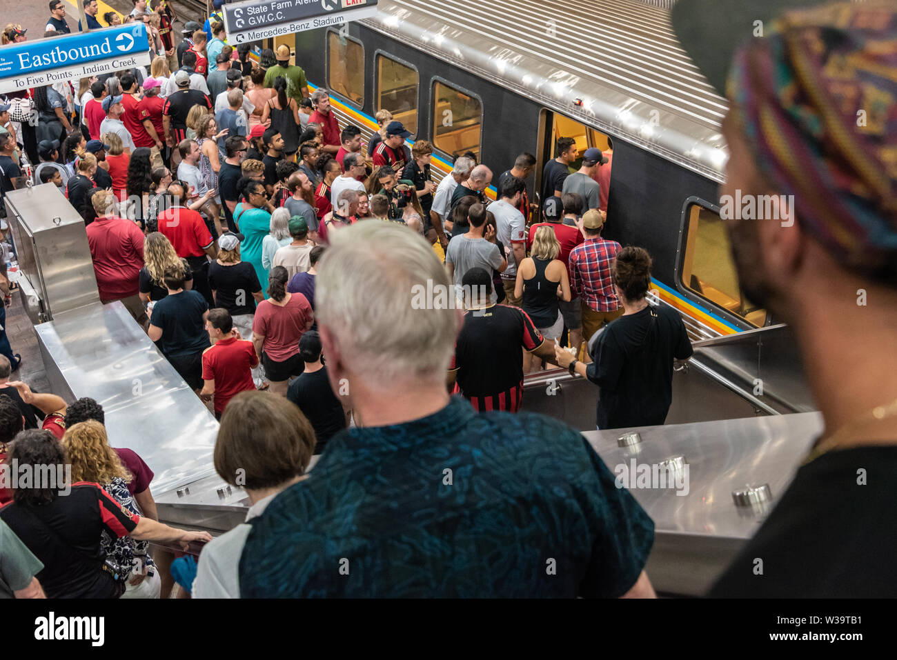 Menschen, die eine Bahn auf einen unterirdischen MARTA-Bahnhof in Atlanta, Georgia in der Nähe von Mercedes-Benz Stadion, State Farm Arena und CNN Center. Stockfoto