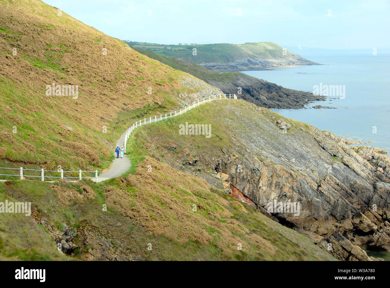 Zwei ältere Menschen zu Fuß auf einer langen küstenweg, Caswell Bay, South Wales Stockfoto