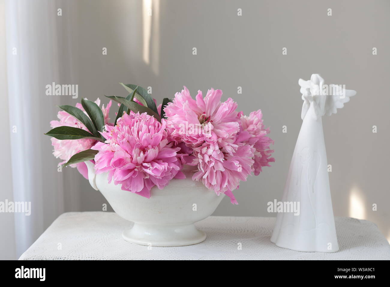 Rosa pfingstrose Blüten in einer weißen Schüssel auf einem weißen Tisch. Weißer Hintergrund. Immer noch leben. Licht am Morgen Licht im Innen weiss. Stockfoto