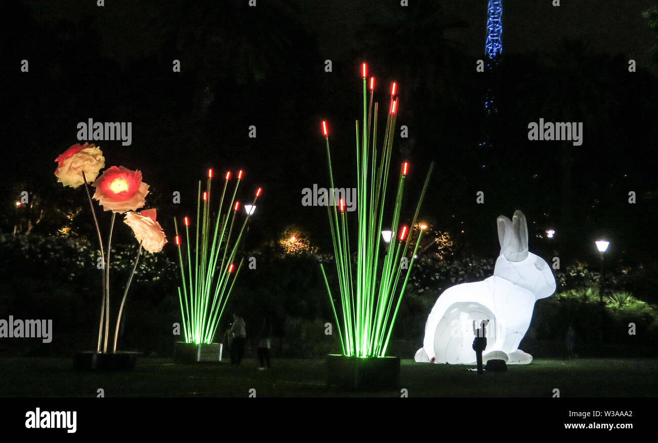 Melbourne Australien: Weiße Nacht arts Festival in Melbourne. Einen riesigen beleuchteten Hasen und Pflanzen Turm groß über einen einsamen Tourist, ein Foto. Stockfoto