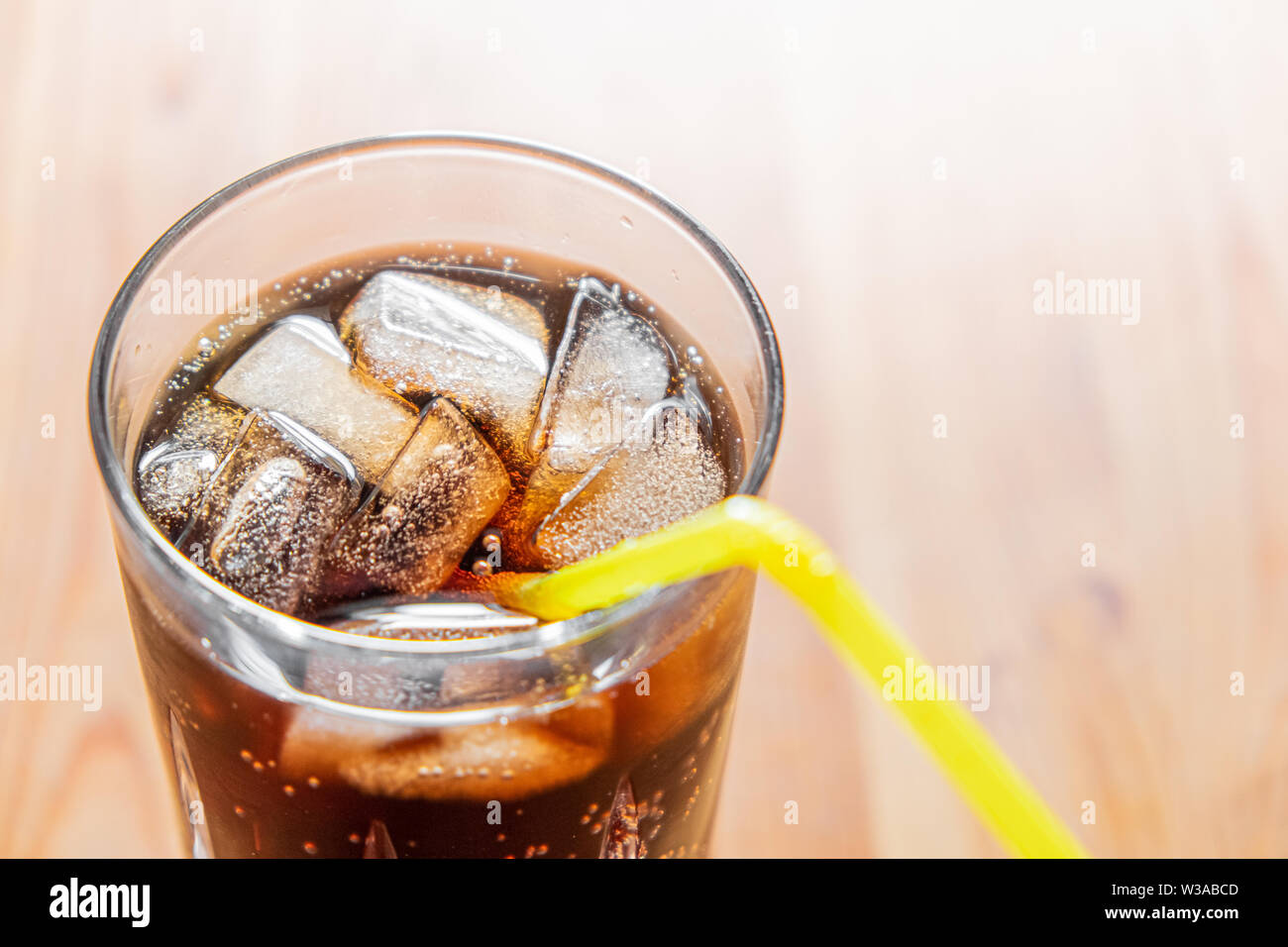 Eisig kalten Getränk im Glas, Nahaufnahme. Glas kühles Mineral Drink mit Eis auf einem Holztisch, detaillierte Schuß Stockfoto