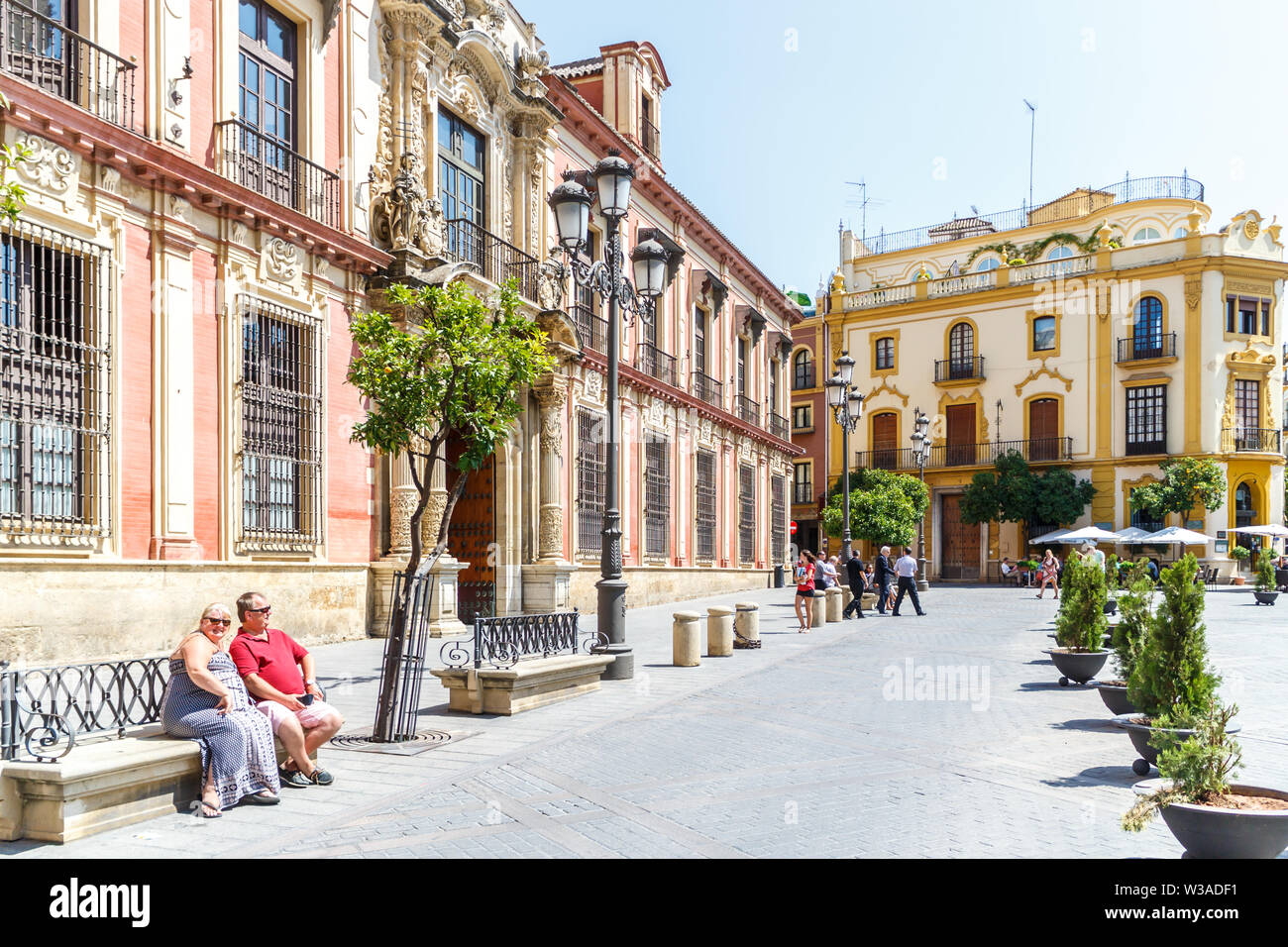 Sevilla, Spanien - 3. September 2015: Touristen sitzen auf einer Bank in der Plaza Virgen de los Reyes. Dies ist einer der wichtigsten Plätze in der Altstadt. Stockfoto