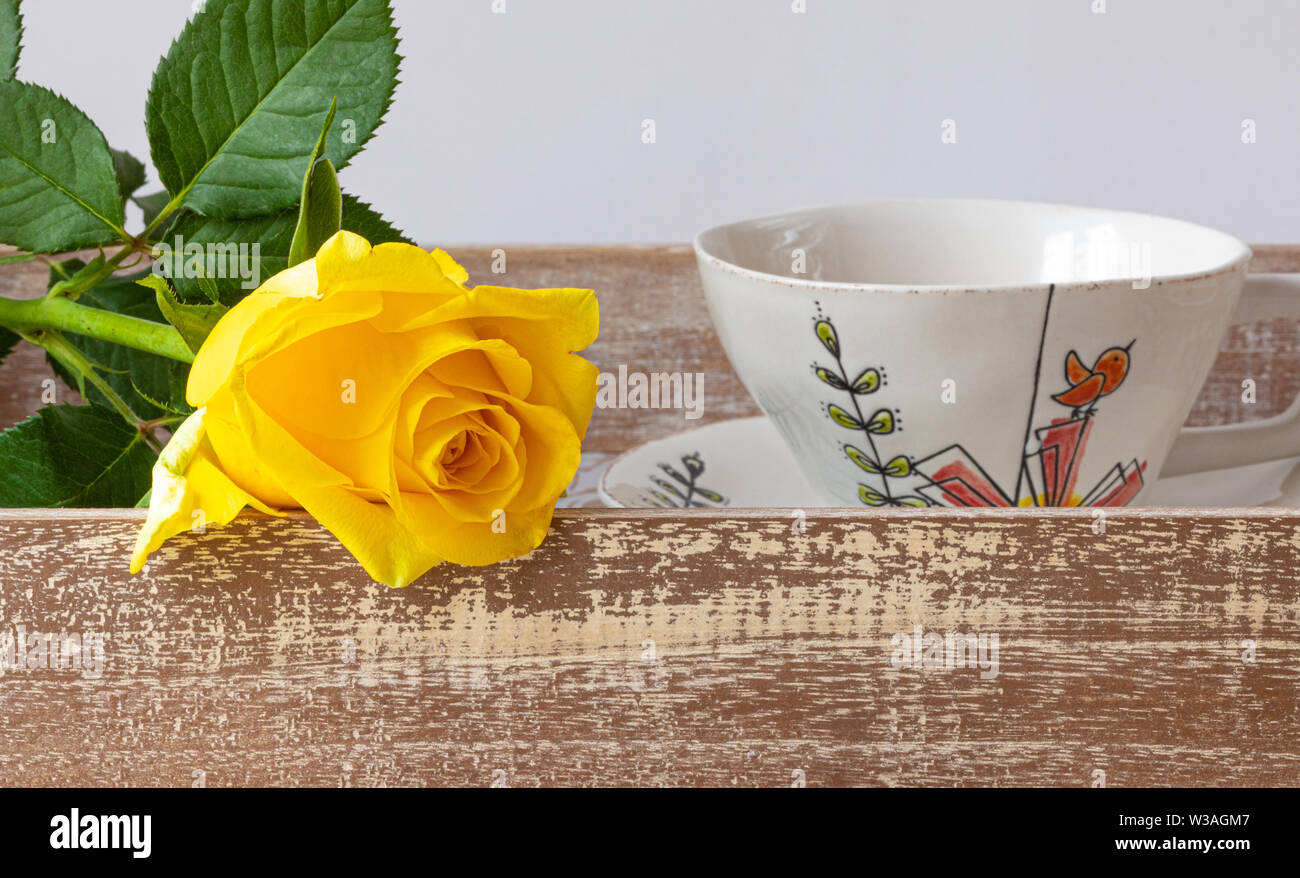 Schöne gelbe Rose mit Tasse Kaffee auf einen hölzernen Tisch. Romantische  Szene Stockfotografie - Alamy