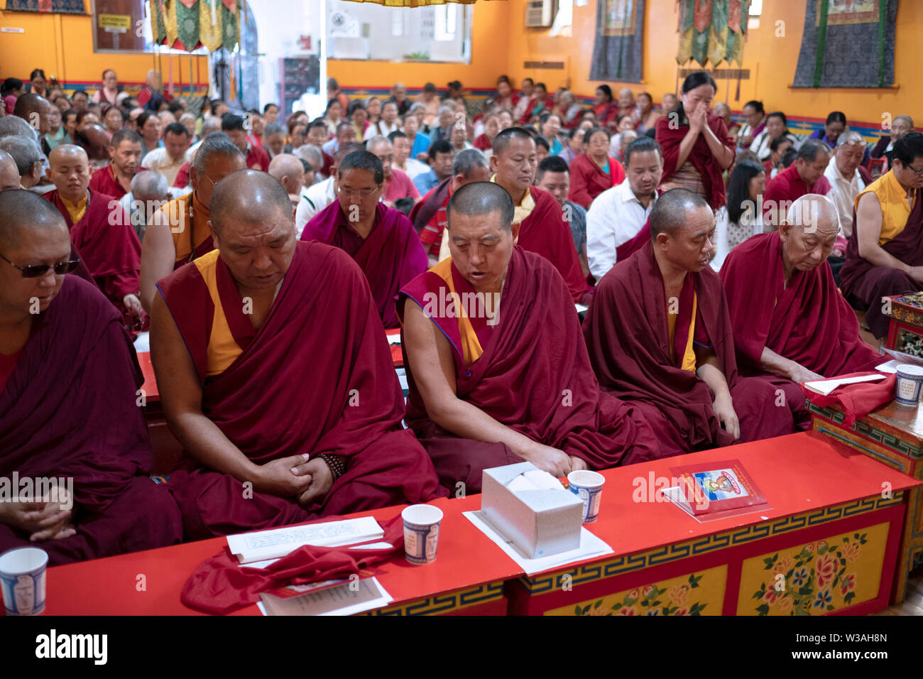 Nepalesische buddhistische Mönche teilen Gebet Bücher zu einem Service an der Sherpa Kyidug Tempel in Elmhurst, Queens, New York City. Stockfoto