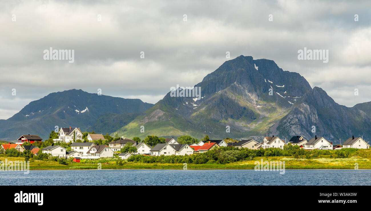 Norwegische Häuser und Hütten am See mit den Bergen im Hintergrund, Leknes, Vestvagoy Gemeinde, Nordland County, Norwegen Stockfoto