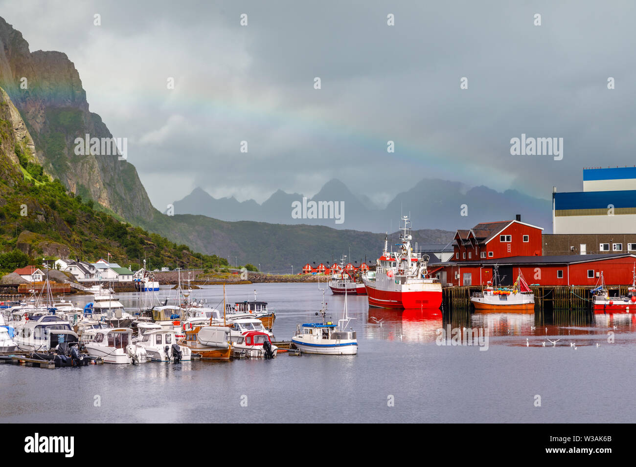 Yachten und Boote mit Bergen im Hintergrund und Rainbow arc am Pier in Svolvaer, Lototen Inseln, Austvagoya, Vagan Gemeinde, Nordland County Stockfoto