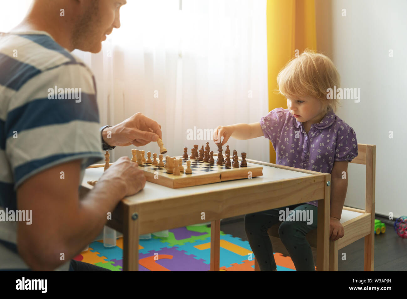 Brain Games - Vater lehrt Schach für sein Kind zu Hause zu spielen Stockfoto