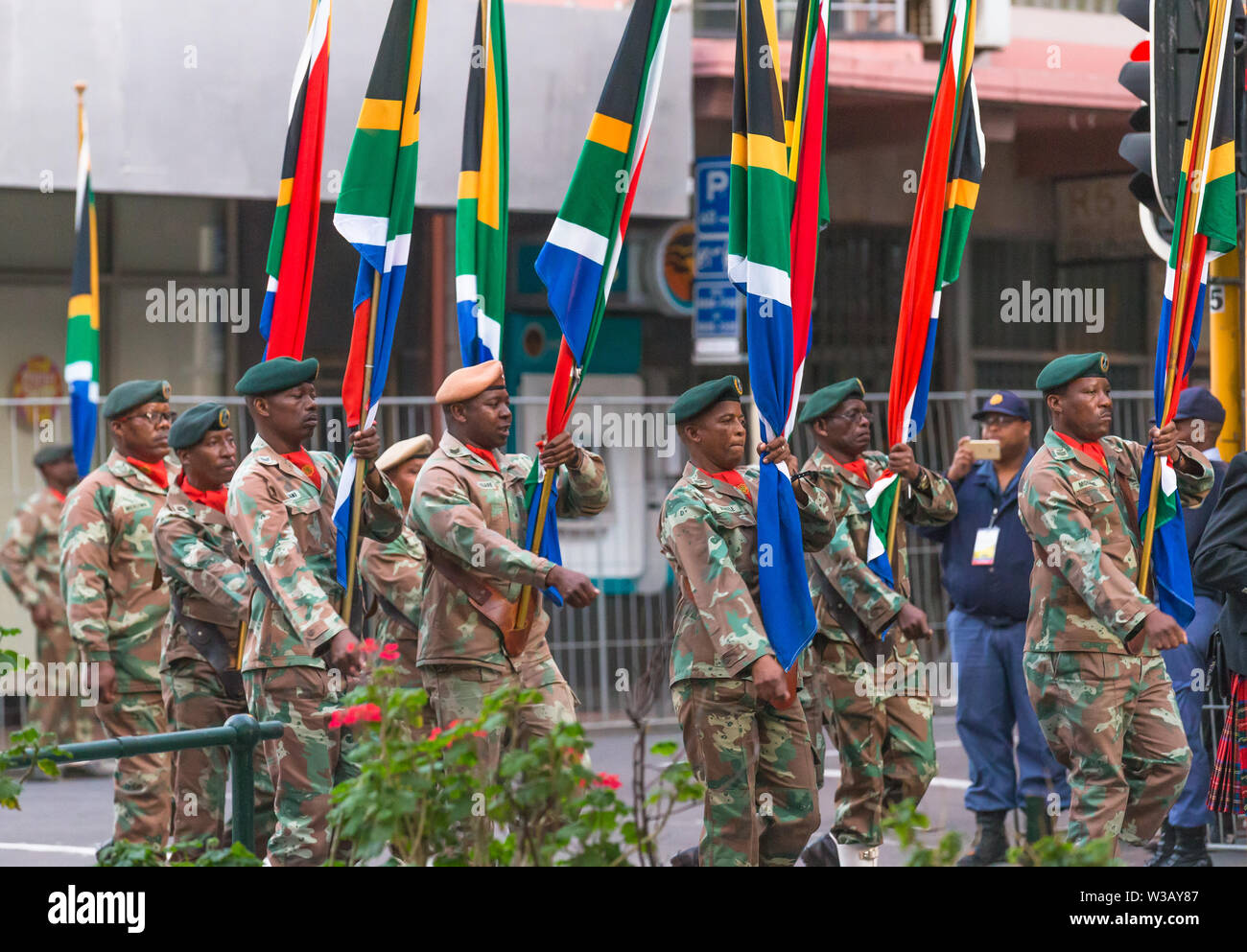 Schwarze afrikanische Männer oder Soldaten und der Armee Mitglieder tragen camouflage Uniform tragen südafrikanischer Flaggen während der Street Parade in Kapstadt, Südafrika Stockfoto
