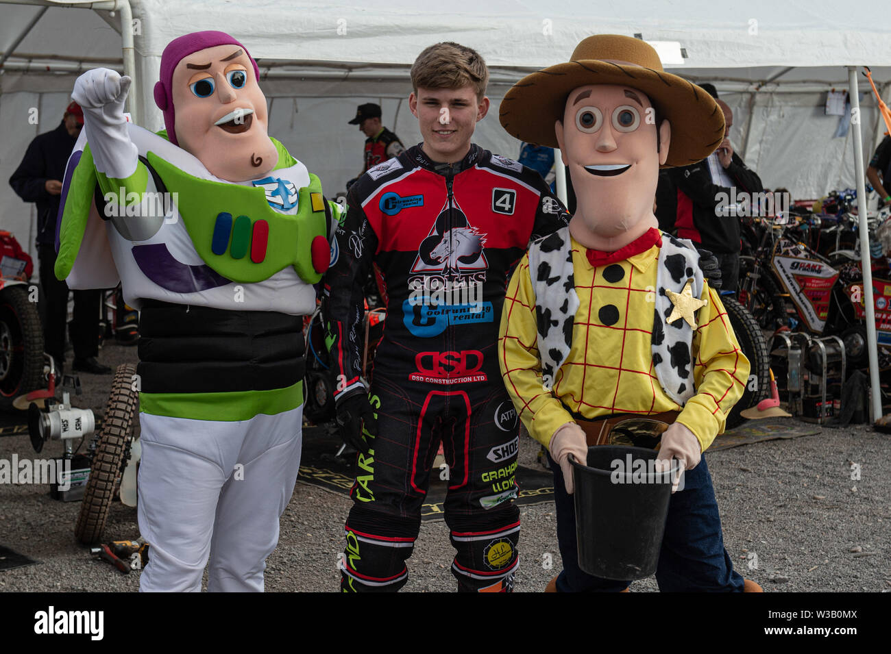 Loomer Rd, Newcastle und, UK. 13. Juli, 2019. Stoke-on-Trent, 14. Juli Belle VueÕs Kyle Bickley mit den beiden Speedway Fahrer wohlwollende Finden Sammler, Buzz Lightyear und Woody während der Nationalen Liga 4 Mannschaft Meisterschaft an Stoke Speedway Stadion, Loomer Rd, Newcastle Under Lyne am Samstag, dem 13. Juli 2019. (Credit: Ian Charles | MI Nachrichten) Credit: MI Nachrichten & Sport/Alamy leben Nachrichten Stockfoto