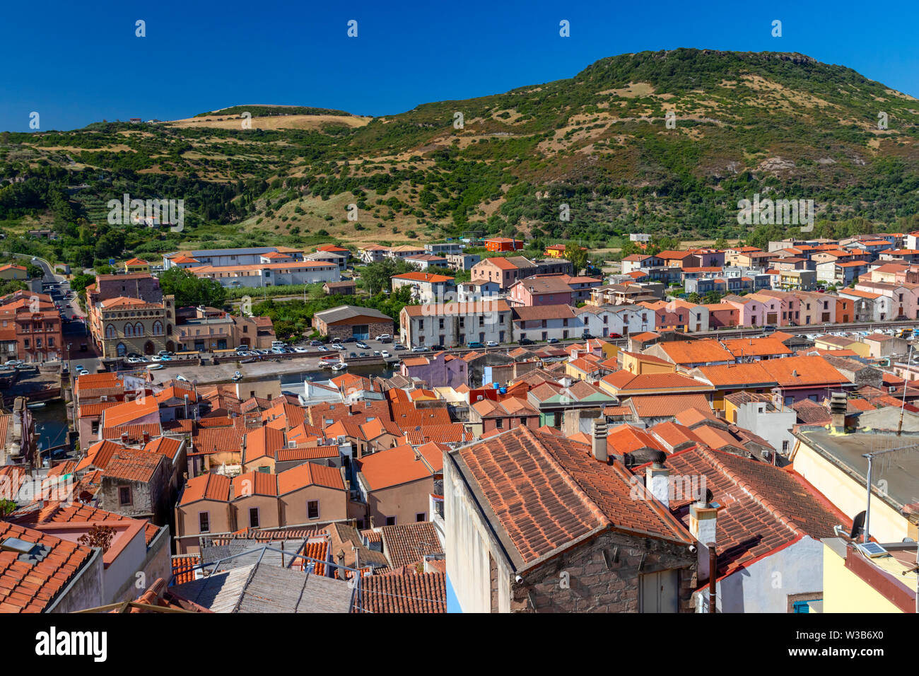 Blick auf Olbia, Sardinien, Italien. Historische Gebäude mit roten rooftiles. Hill und blauer Himmel im Hintergrund. Stockfoto