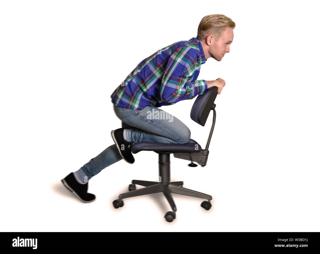 Junger Bürotrainee fährt auf einem Bürostuhl Stockfoto