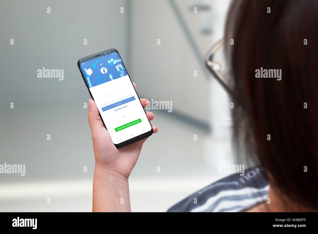 SARAJEVO, BOSNIEN UND HERZEGOWINA - Juli 14, 2019: Frau mit smart phone mit einer neuen überarbeiteten Version von Facebook. Der Begriff Fortschritt und Soc Stockfoto
