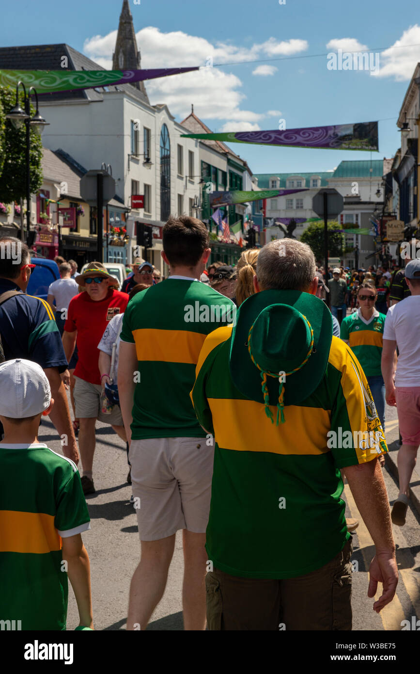 Spieltag in Killarney, County Kerry, Irland. Fans der gälischen Kerry-Fußballfans auf der High Street vor dem Spiel von Mayo und Kerry im Juli 2019. Geschäftige irische Stadt. Die Stadt Killarney war an einem sonnigen Tag voller Fußballfans. Stockfoto