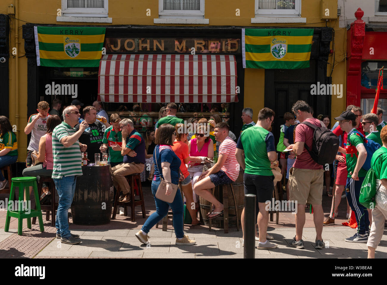 Spieltag Killarney Irland Menschen genießen das schöne Wetter vor der Bar von John M. Reidi und die Fans des gälischen Fußballs an einem Spieltag in Killarney, County Kerry, Irland Stockfoto