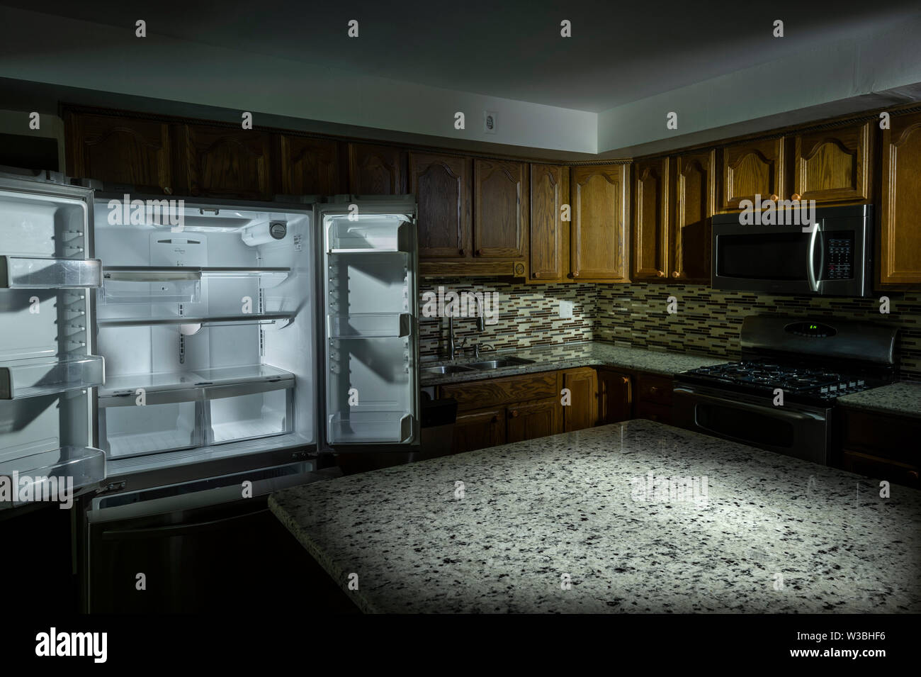 Dunkle Leere Küche im Innenbereich im Haus mit stimmungsvoller Beleuchtung Stockfoto