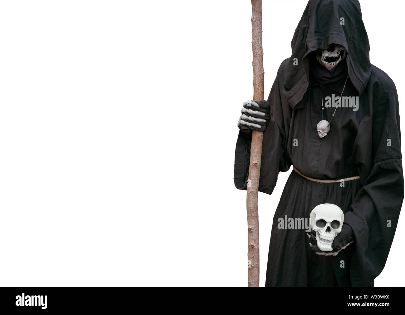 Grim Reaper hält einen Totenschädel in der Hand, auf einem weissen Hintergrund. Stockfoto