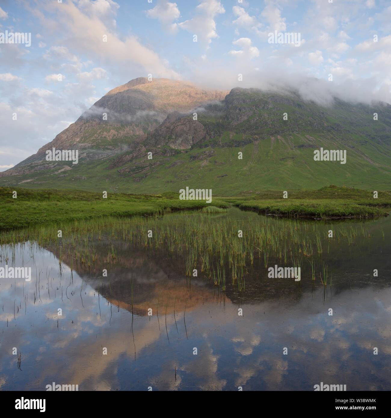 Der westlichste Gesicht der Buachaille Etive Mor in den stillen Wassern des Lochan Na Fola spiegelt sich auf einen späten Sommer Abend Stockfoto