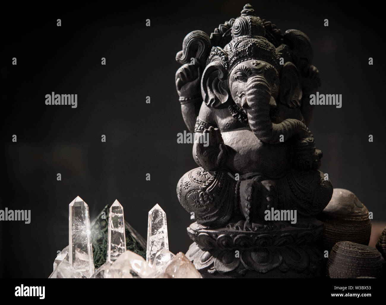Hindu Tempel mit einem schwarzen Statue von Ganesh auf dem Altar. Kristalle aus Quarz an der Basis Stockfoto